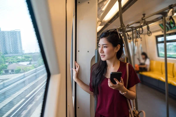 Mujer asiática pasajero usando smartphone — Foto de Stock