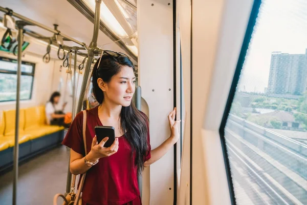 Азиатка пассажир с помощью смартфона — стоковое фото