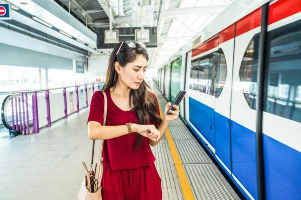 Asyalı kadın yolcu izlerken saat 