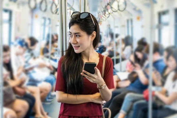 Ασιατικές γυναίκα επιβάτη χρησιμοποιώντας το κοινωνικό δίκτυο — Φωτογραφία Αρχείου