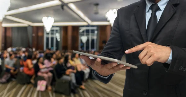 Zakenman met behulp van Tablet PC op foto's voor conferentiezaal — Stockfoto