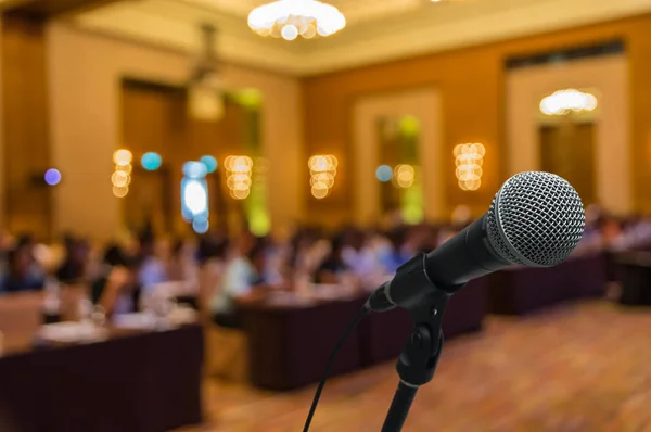 Microphone over blurred photo of conference hall — Stock Photo, Image