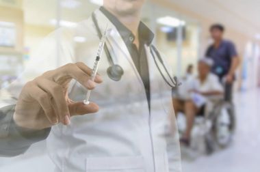 Doktor el şırınga tutarak 