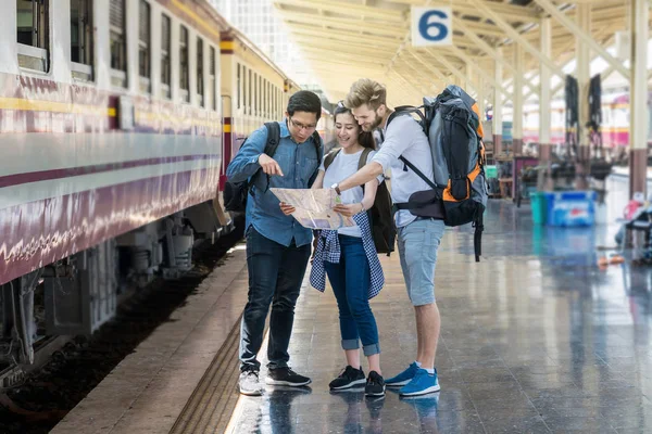 Viajantes multiétnicos olhando para o trem — Fotografia de Stock