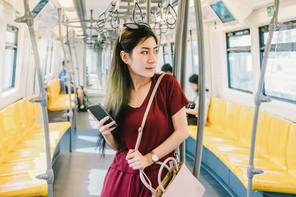 Asyalı kadın yolcu ile akıllı telefon 