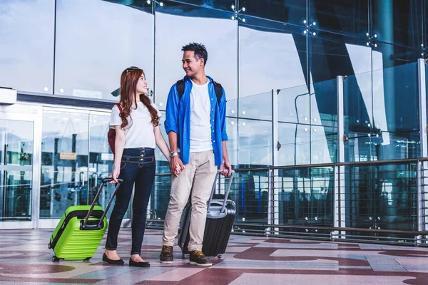 亚洲情侣在机场带手提箱的旅行者 科技理念下的情侣旅游与交通 — 图库照片