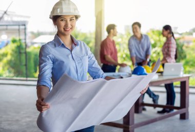 Planı ile çalışma ve kask ve gözlük şantiye giyen mutlu profesyonel inşaat mühendisi kadın portresi yer arka plan