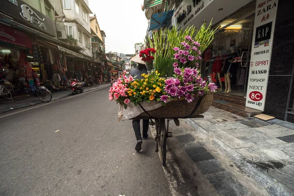 Hanoi, Vietnam - Sept 2017: Hanoi yürüyüş arasında çiçek satan tanımsız kadın tüccar geleneksel sokak hawker. Vietnam üzerinde 24 Eylül 2017.
