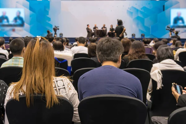 Спикеры на сцене с задним видом на аудиторию в конференц-зале — стоковое фото