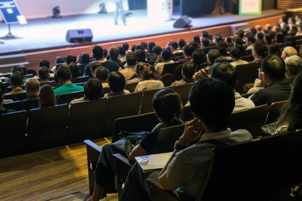 观众的后观在会议厅或研讨会的舞台上聆听演讲者在低光情况下 商业和教育投资理念 — 图库照片