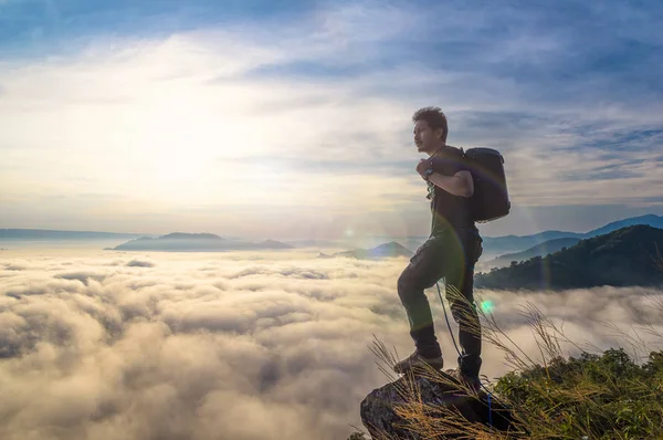 旅行バックパッカー Pha Nong Khai タイで日の出とレンズのフレアとの朝の霧の風景と山に立って — ストック写真