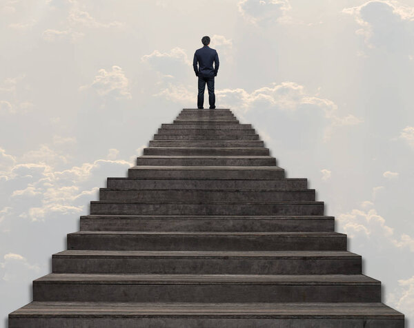Бизнесмен, стоящий за восхождение по лестнице на фоне облака и неба, успешный бизнес и амбиции концепции
