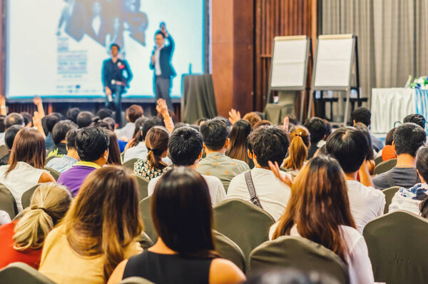 Speaker on the stage with Rear view of Audience in the conference hall or seminar meeting, business and education concept