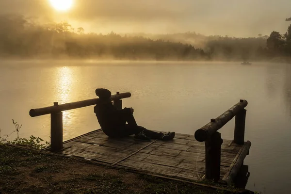 日の出の時間 劇的なと孤独概念で屋形船川湖上に座ってシルエット落ち込んでいる男 — ストック写真