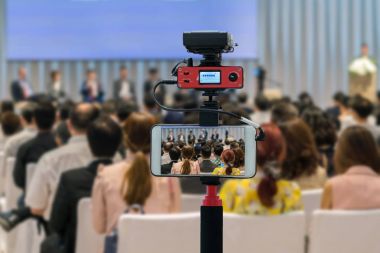Closeup akıllı cep telefonu Live sahnede seyirci arkadan görünüş konferans salonu veya seminer toplantı, teknoloji canlı streaming ve yayın kavramı ile hoparlörler alarak