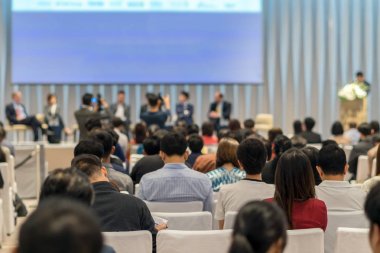 Sahnede, iş ve eğitim yatırım kavramı hakkında hoparlörlere sahip konferans salonu veya seminer toplantı seyirci görünümünde arka