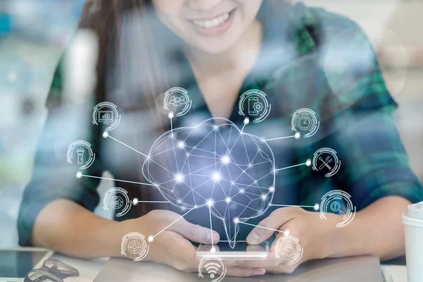 Polygonal brain shape of artificial intelligence with various icon of smart city Internet of Things Technology over Asian businesswoman hand using smart mobile phone, AI and business IOT concept