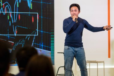 Sahne Alanı'ndaki iş veya eğitim seminer sunum ekran üzerinde rahat takım elbise ile Asya hoparlör closeup portresi