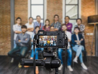 Grup Asyalı ve çok ırklı iş insanlar rahat takım elbise, fotoğrafçı ya da Video ve Live Streaming kavramı için fotoğraf makinesi ile video blog kayıt mikrofon ile profesyonel dijital Mirrorless fotoğraf makinesi