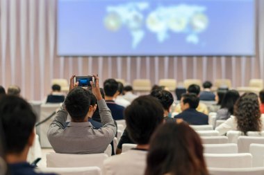 Kimin tarafından sahnede, iş ve eğitim yatırım kavramı hakkında gidiş hoparlörler önce konferans salonu veya seminer toplantı akıllı cep telefonu fotoğraf seyirci arkadan görünüş