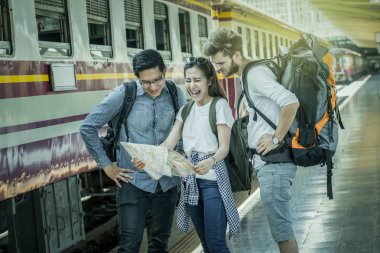Çok ırklı gezginler tren istasyonu, seyahat ve ulaşım kavramı haritaya bakıp duruyorsun