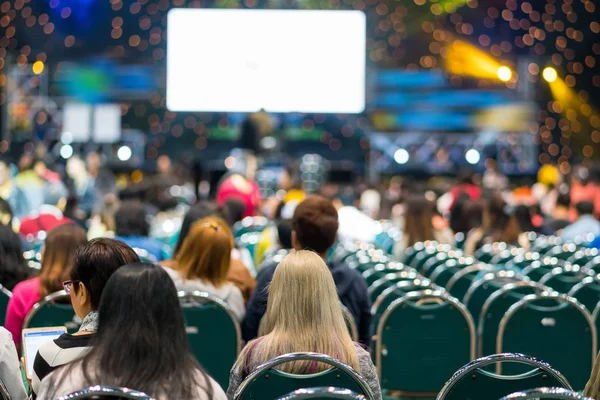 Sahnede, iş ve eğitim yatırım kavramı hakkında hoparlörlere sahip konferans salonu veya seminer toplantı seyirci görünümünde arka