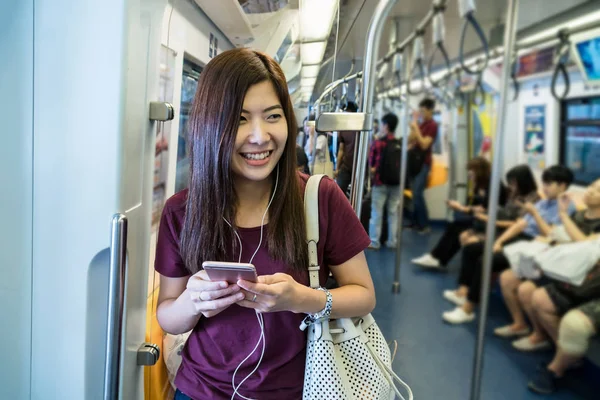 大きな都市 ライフ スタイル 交通機関の概念の旅行のための地下鉄でスマートな携帯電話を使用してカジュアルなスーツでアジアの女性乗客 — ストック写真