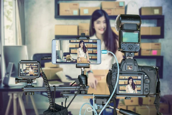 スマートな携帯電話とカメラのオンライン ショッピング 起業家コンセプトのライブストリーミングのためアジア若者所有者ビジネス女性仕事自宅で三脚にアクション カメラ専門セット — ストック写真