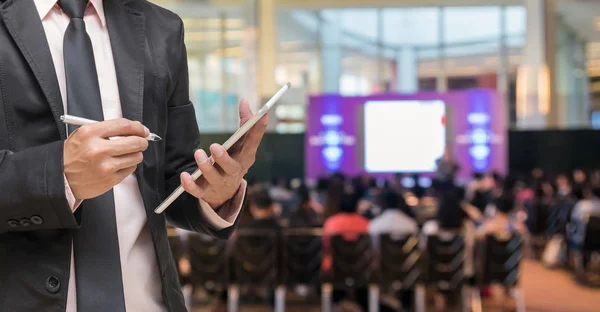 Geschäftsmann Mit Tablet Mikrofon Über Abstraktes Verschwommenes Foto Von Konferenzsaal — Stockfoto