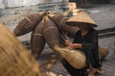 Closeup eski Vietnam kadın ustası geleneksel bambu tuzak balık veya tarih Prş sy ticaret Köyü, Hung Yen, Vietnam, geleneksel sanatçı kavramı eski geleneksel evinde örgü yapma