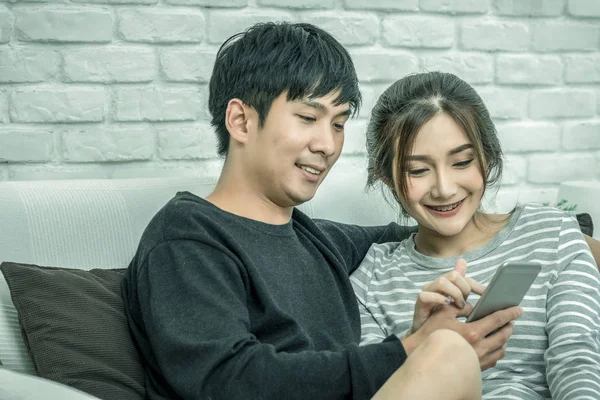 Glückliches Asiatisches Paar Das Sitzt Und Das Digitale Smartphone Benutzt — Stockfoto