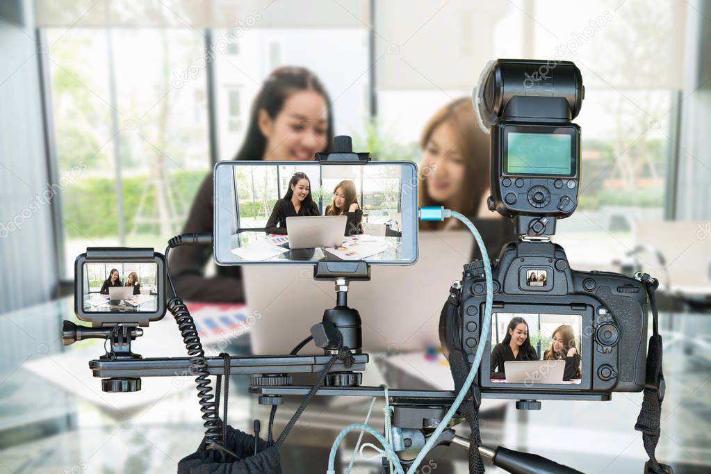 Professional set of camera with smart mobile phone and action camera on tripod over Two Asian young Businesswoman giving the interview via Live stream, Live Streaming for entrepreneur concept