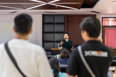Asya Hoparlör veya konferans salonu veya seminer toplantı odasında projektör ekranı üzerinden sunum sahnede rahat takım elbise ile ders Seyirci, iş eğitimi ve Seminer kavramı