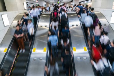 Metroya ulaşmadan önce, Hong Kong, Merkez Bölgesi 'nde, metro taşıma merkezinde, yoğun saatlerde yürüyen yürüyen yürüyen merdivende tanınmayan kalabalık, hızlı hareket ve iş insanları kavramı.
