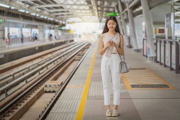 在大城市 日本人 中国人 韩国人的生活方式和日常生活 通勤者和交通观念中 年轻的亚洲女性乘客在乘坐地铁时 通过智能手机使用社交网络 — 图库照片