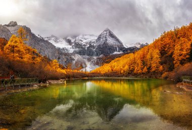 Pearl Gölü 'nün Panorama' sı. Sonbahar mevsiminde kutsal kar dağı Sichuan Eyaleti 'nin güneybatısında, Daocheng İlçesi' nde. Seyahat ve turizm, ünlü bir yer ve konsept.