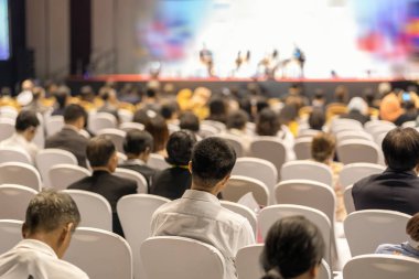 Konferans salonu veya Seminer Toplantı, iş ve eğitim yatırım kavramı hakkında sahnede hoparlörler dinleme seyirci arkadan görünüş
