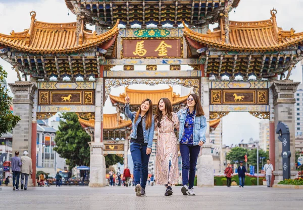 三个亚洲快乐的女人一起走过昆明金碧广场 带着友谊的理念旅行和旅游 中文文本是金马 — 图库照片