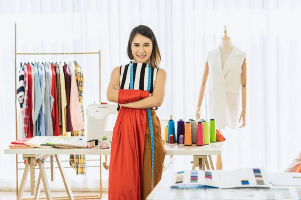 Portrait Young Asian Designer woman are arms crossed at workplace over Clothes mannequins, small business startup, Business owner entrepreneur, modern freelance job lifestyle concept.asean people