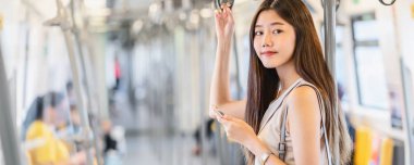 Banner, web sayfası ya da metroda seyahat ederken sosyal ağı kullanan Asyalı kadın yolcu şablonu büyük şehir, Japonca, Çince, Kore yaşam tarzı konsepti