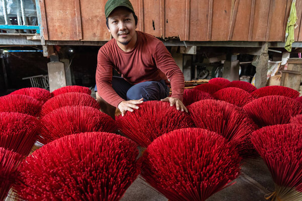 Asian traveler male making the traditional vietnam red insense in old traditional house at long xuyen, an giang province, vietnam,traditional and culture concept