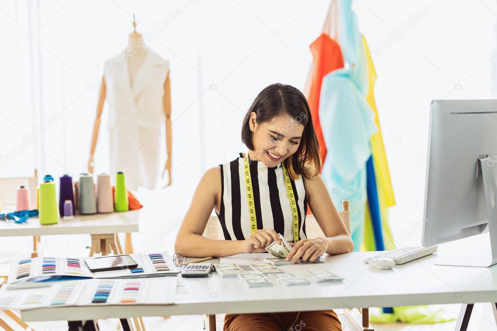 Portrait Young Asian Designer woman working and Counting money at workplace, small business startup,Business owner entrepreneur, investment and profit, freelance job lifestyle concept.asean people