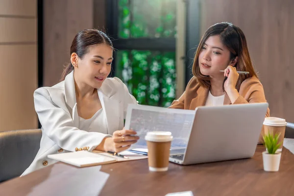 两名亚洲女商人在现代会议室 办公室或工作空间 咖啡休息时间 伴侣和同事概念中 与伙伴企业合作 使用纸质图表文件和技术笔记本电脑 — 图库照片