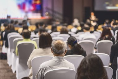 Konferans salonu veya Seminer Toplantı, iş ve eğitim yatırım kavramı hakkında sahnede hoparlörler dinleme seyirci arkadan görünüş