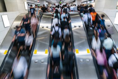Metroya ulaşmadan önce, Hong Kong, Merkez Bölgesi 'nde, metro taşıma merkezinde, yoğun saatlerde yürüyen yürüyen yürüyen merdivende tanınmayan kalabalık, hızlı hareket ve iş insanları kavramı.