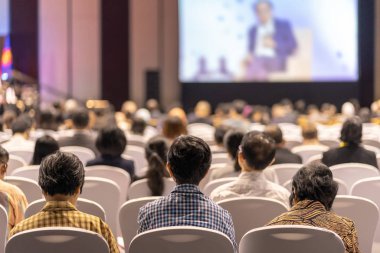 Konferans salonu veya Seminer Toplantı, iş ve eğitim yatırım kavramı hakkında sahnede hoparlörler dinleme seyirci arkadan görünüş
