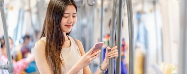 Banner, web sayfası ya da metroda seyahat ederken sosyal ağı kullanan Asyalı kadın yolcu şablonu büyük şehir, Japonca, Çince, Kore yaşam tarzı konsepti