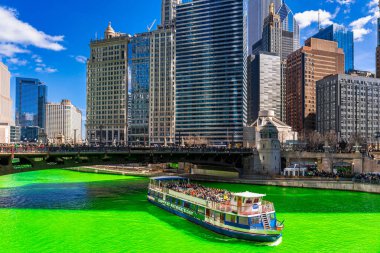 Chicago, Illinois, Usa 'daki yeşil renkli nehri boyayan Şikago nehri çevresindeki Aziz Patrick gününde Chicago' daki bina ve şehir manzarası taçlandırılmış İrlandalıları ve Amerikan halkını kutluyor..
