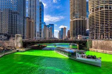 Chicago, Illinois, Usa 'daki yeşil renkli nehri boyayan Şikago nehri çevresindeki Aziz Patrick gününde Chicago' daki bina ve şehir manzarası taçlandırılmış İrlandalıları ve Amerikan halkını kutluyor..