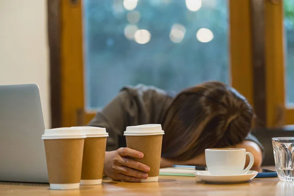アジアの実業家は 彼女の技術のラップトップと同僚のスペースやコーヒーショップで多くの紙コーヒーカップで一生懸命働いて寝て 排気と感情的なストレスの概念 — ストック写真